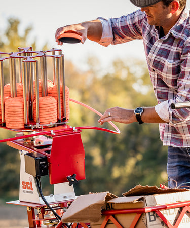 Do All Outdoors SCI Exclusive Trap Thrower with man loading clay pigeons.